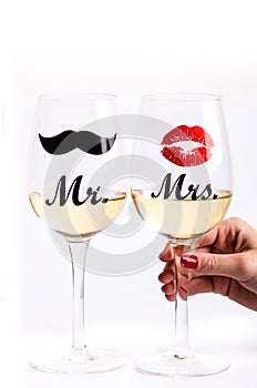 Glass of wine with womanÂ´s hand on a white background. Glasses for woman and man. White wine. Happy lifestyle. Romantic.