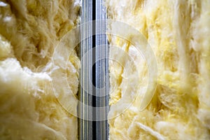 Glass wool between metal profiles in the wall. Universal insulation material for sound and heat insulation