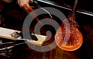 Glass worker shaping and cooling glass material