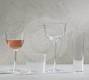 A glass of yellow Zinfandel and four empty wine glasses