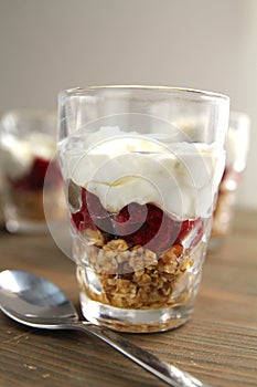 Glass with yogourt, berry coulis and nuts photo