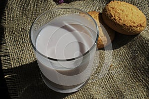 Glass of yogurt with cookies on a blue plate
