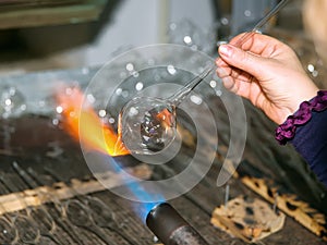 Glassblower heats the glasspiece