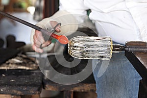 Glassblower shaping molten glass