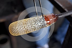 Glassblower shaping molten glass