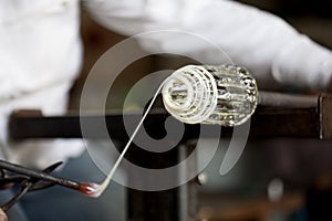 Glassblower shaping wrapping molten glass