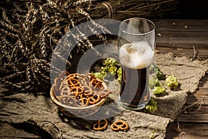 Glasse beer with wheat and hops, basket of pretzels