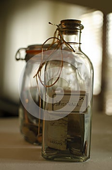 Glassed money box with coins, made from jar. Money saved for trips.