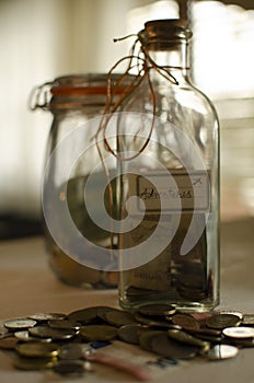 Glassed money boxes with coins made from two jars. Money saved for trips.