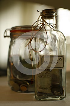 Glassed money boxes with coins made from two jars. Money saved for trips. photo