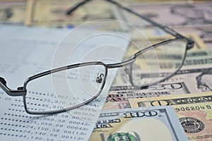 Glasses and account book on dollar bank note photo