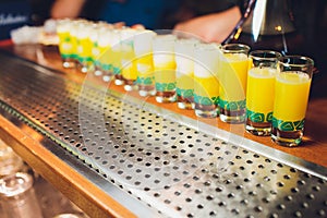 Glasses with an alcoholic drink on a damp glass table.