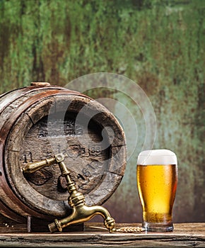 Glasses of beer and ale barrel on the wooden table.