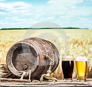 Glasses of beer and ale barrel on the wooden table.