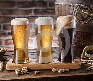 Glasses of beer and ale barrel on the wooden table. Craft brewer