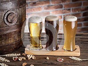 Glasses of beer and ale barrel on the wooden table. Craft brewer