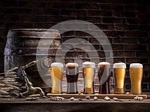 Glasses of beer and ale barrel on the wooden table. Craft brewery photo