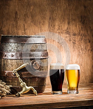 Glasses of  beer and ale barrel on the wooden table. Craft brewery