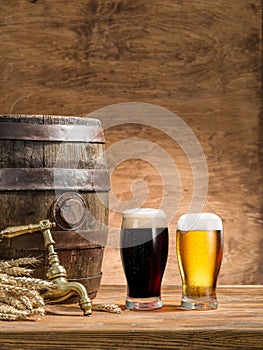 Glasses of  beer and ale barrel on the wooden table. Craft brewery
