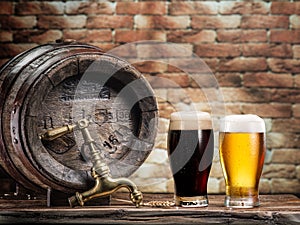 Glasses of  beer and ale barrel on the wooden table. Craft brewery