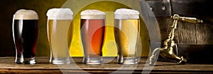 Glasses of beer and beer cask on the wooden table. Craft brewery