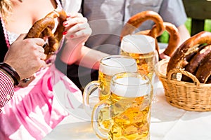 Glasses of beer and pretzel in German beer garden
