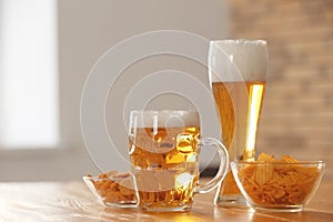 Glasses with beer and snacks on table in bar
