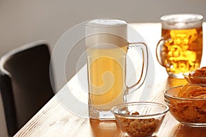 Glasses with beer and snacks on table in bar