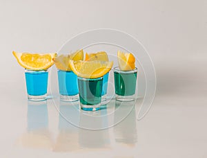 Glasses with blue and green kamikaze, glamorous drink, mixed drink poured into shot glasses