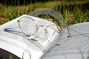 Glasses on a book with grass photo