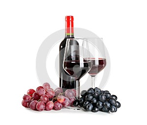 Glasses and bottle of red wine with ripe grapes on white background