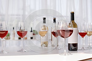 Glasses and bottles with delicious wine on table