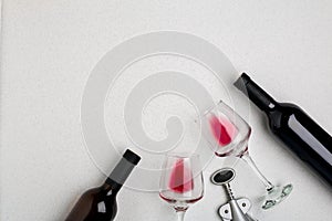 Glasses and bottles of red and white wine on white background from top view