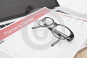 Glasses on calender planner meeting on desk office. organization