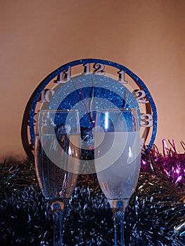 Glasses with champagne on the background of the clock. The clock