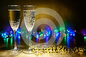 Glasses of champagne on a bright background with garlands