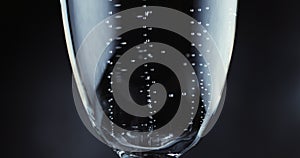 Glasses with champagne bubbles on dark background