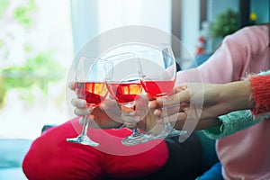 Glasses of champagne close up, celebration, eating and holidays concept - hands clinking wine glasses, Focus on hands toasting red