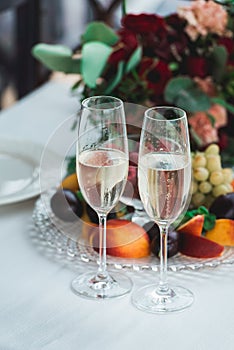 Glasses with champagne drink on a table. Happy newlyweds drinking. Loving couple created new family.