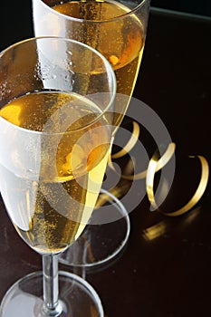 Glasses of champagne and gold streamer photo
