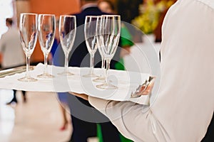 Glasses of champagne ready to be served by a waiter