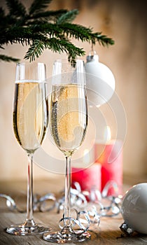 Glasses of champagne under decorated christmas tree branch