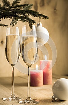 Glasses of champagne under decorated christmas tree branch