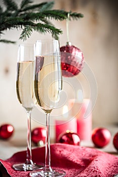 Glasses of champagne under decorated christmas tree branch