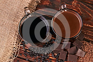 Glasses of chocolate milkshake on wooden table closeup