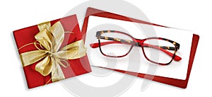 Glasses christmas gift card, red box with glittering golden ribbon bow, white ticket and eyewear isolated on white background,