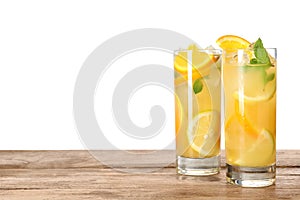 Glasses of citrus refreshing drink on wooden table