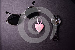 glasses and clock in the style of steampunk with a pink heart in the center on a black background
