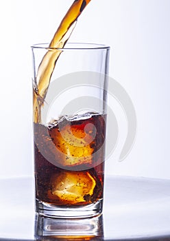 Glasses of cola with ice cubes served with a splash