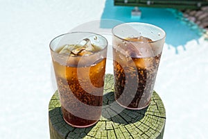 Glasses with cola and ice at the pool on summer holidays